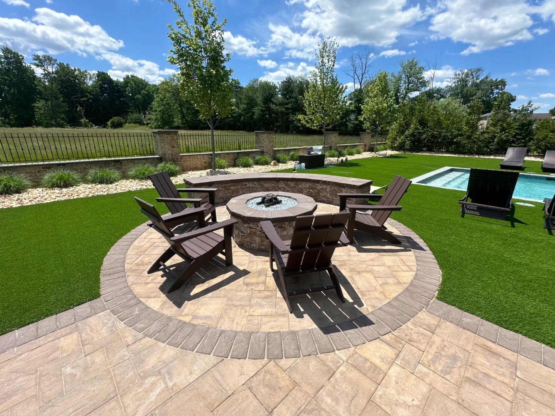 Paver patio with a fire pit and Adirondack chairs in North Caldwell, Essex County, NJ by Masonry Pro